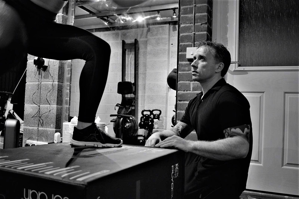 Personal trainer supervising box jumps at Simply Fitt Gym